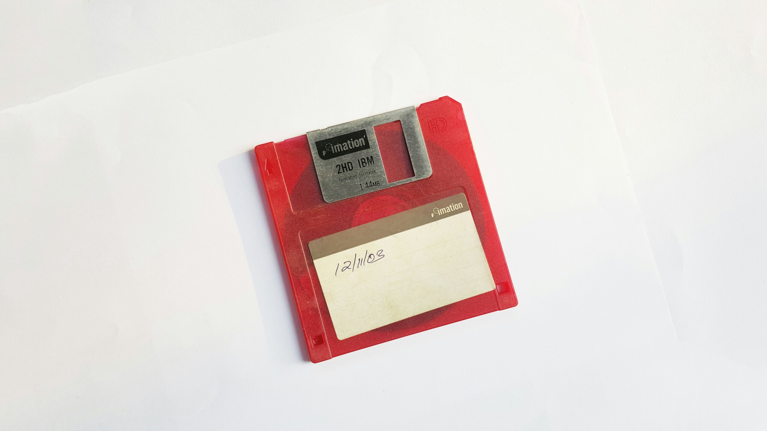 Old red floppy disc on a white background.